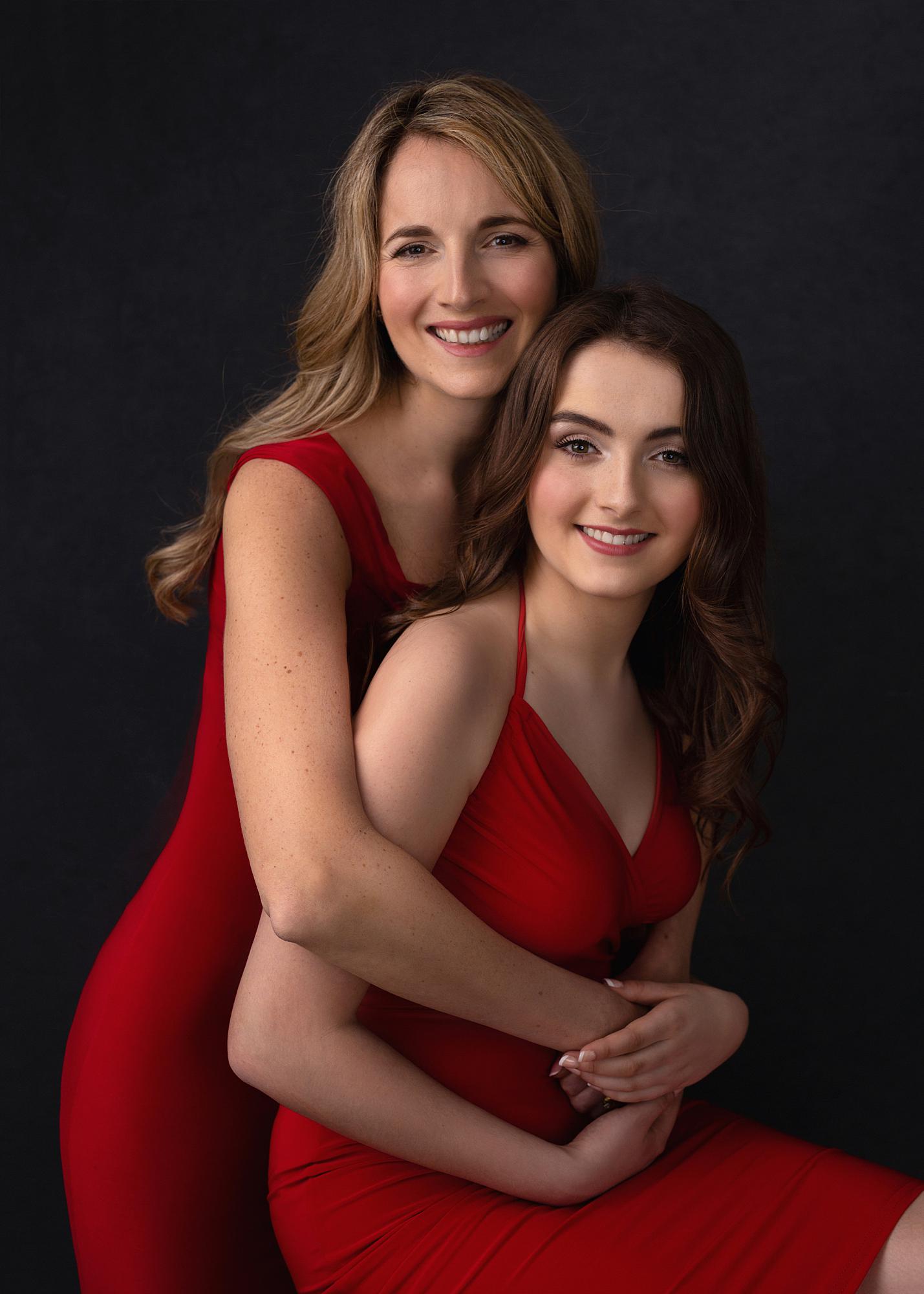 Mother and daughter pose for Beauty Shoot Photoshoot in a Suffolk studio wearing red dresses