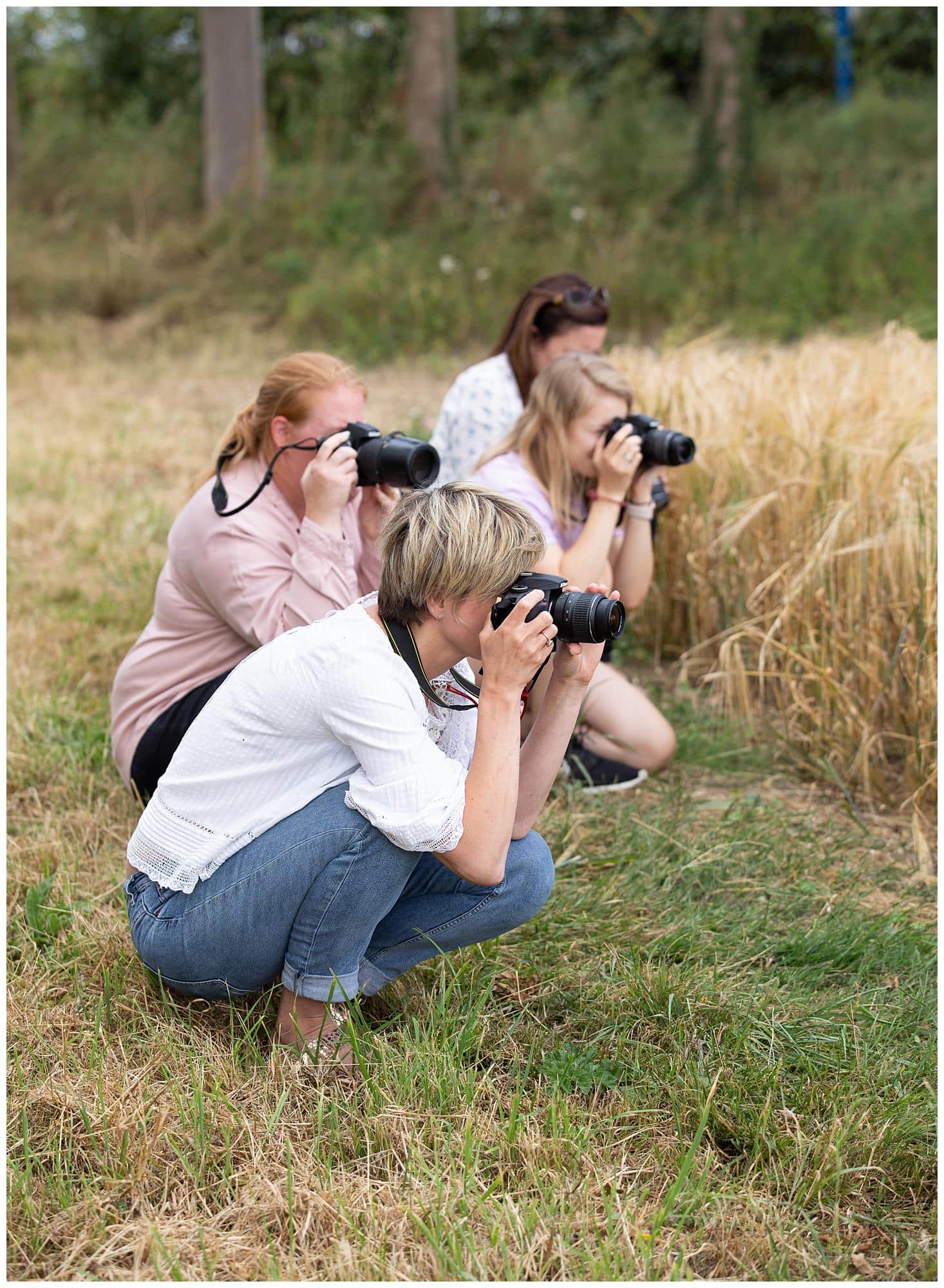 Four Female Photographers take photos with their camera's during a Beginners Photography Workshop in Stoke By Clare, Suffolk