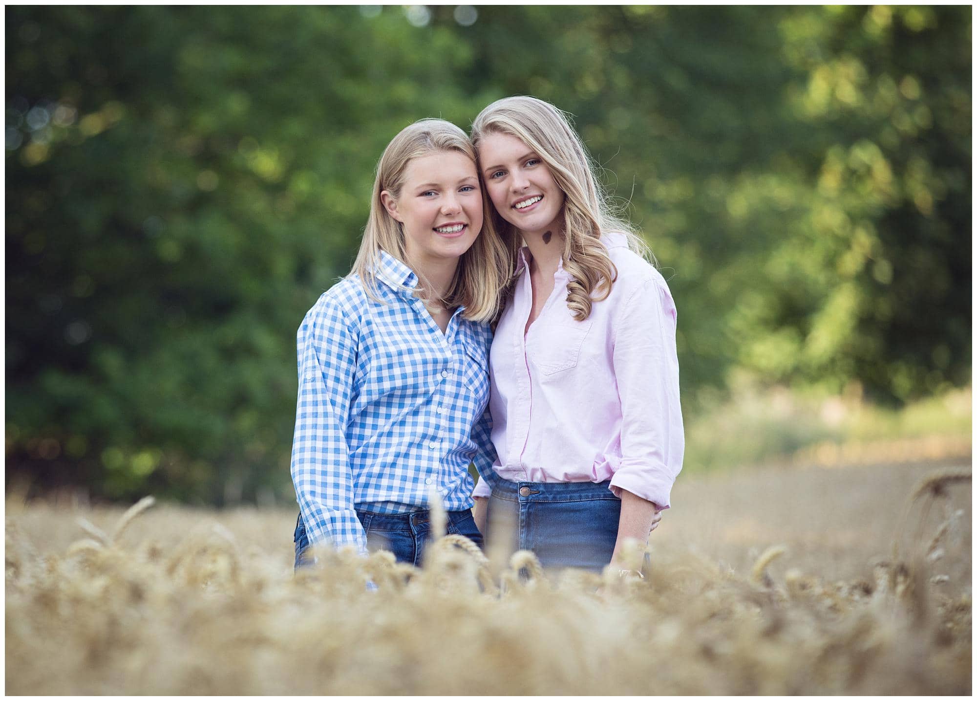 Two sisters standing in a wheat field on a farm in Suffolk