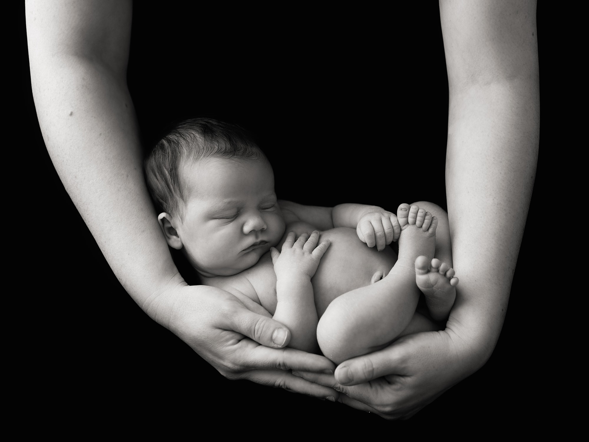 Black and white image of Newborn Baby Photographed in Mothers arms