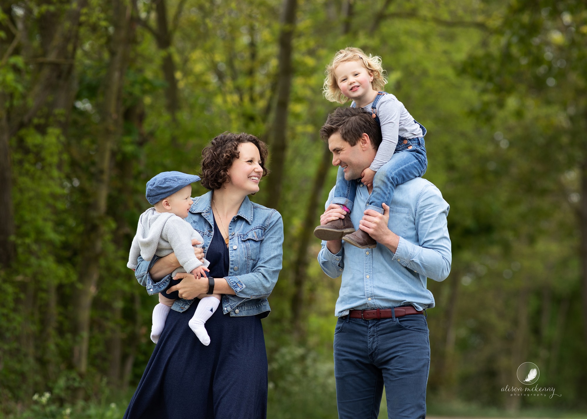 A family of four walking on a country lane during a Summer family photoshoot