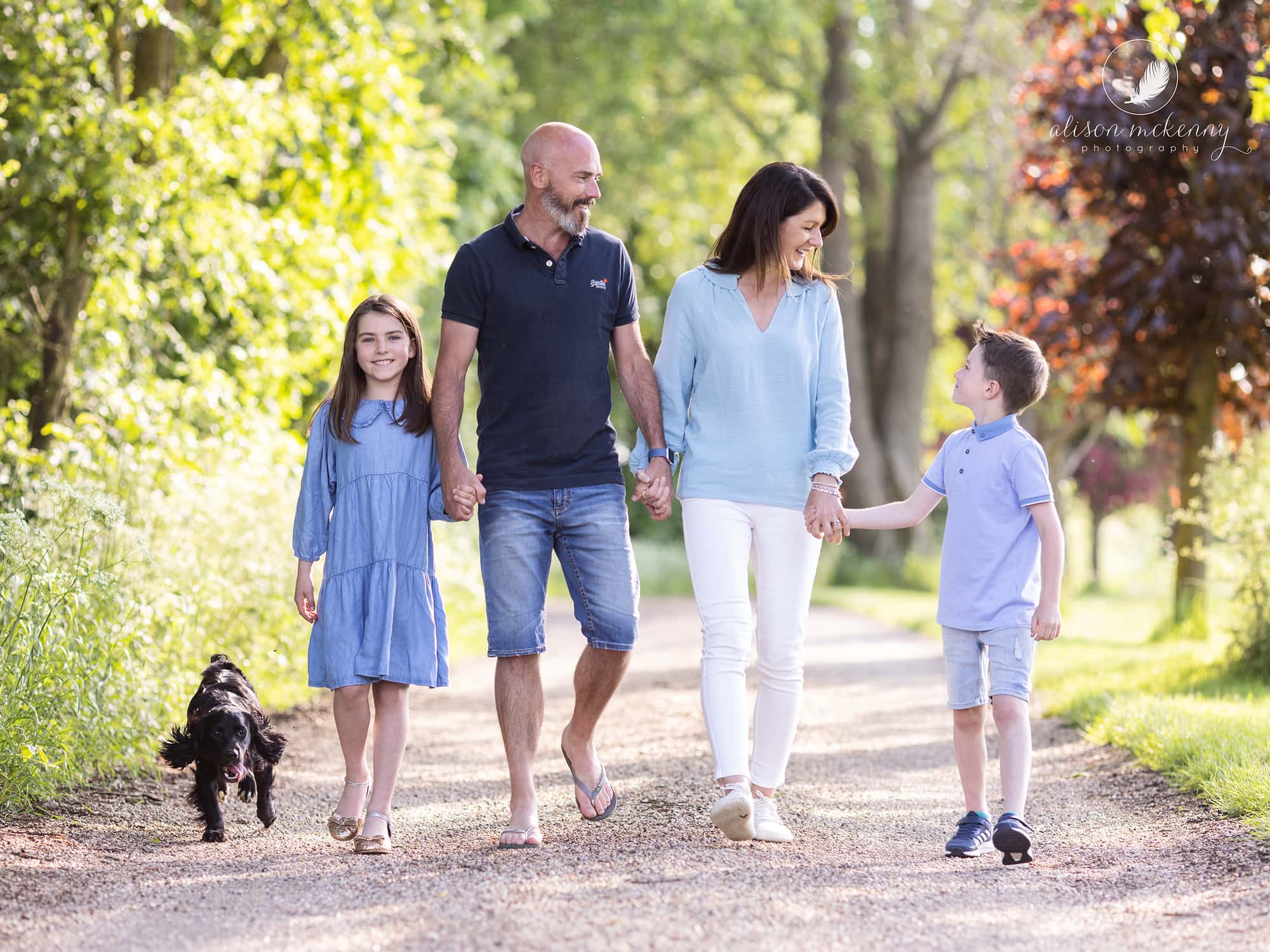 A family and their dog walking on a country lane during a Spring family photoshoot