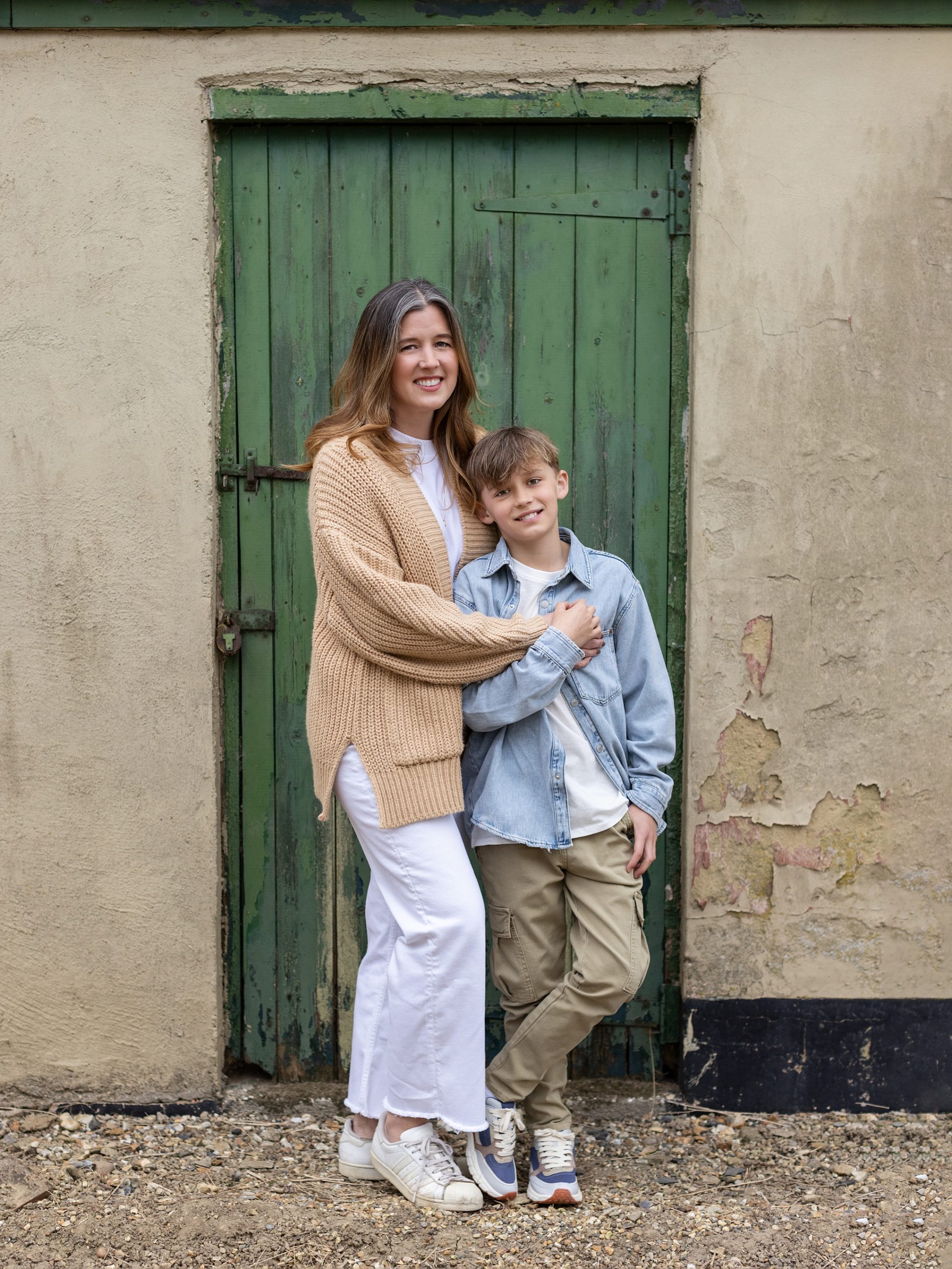 Mother and Son stand in front of an old green door during a Family Photoshoot in Suffolk