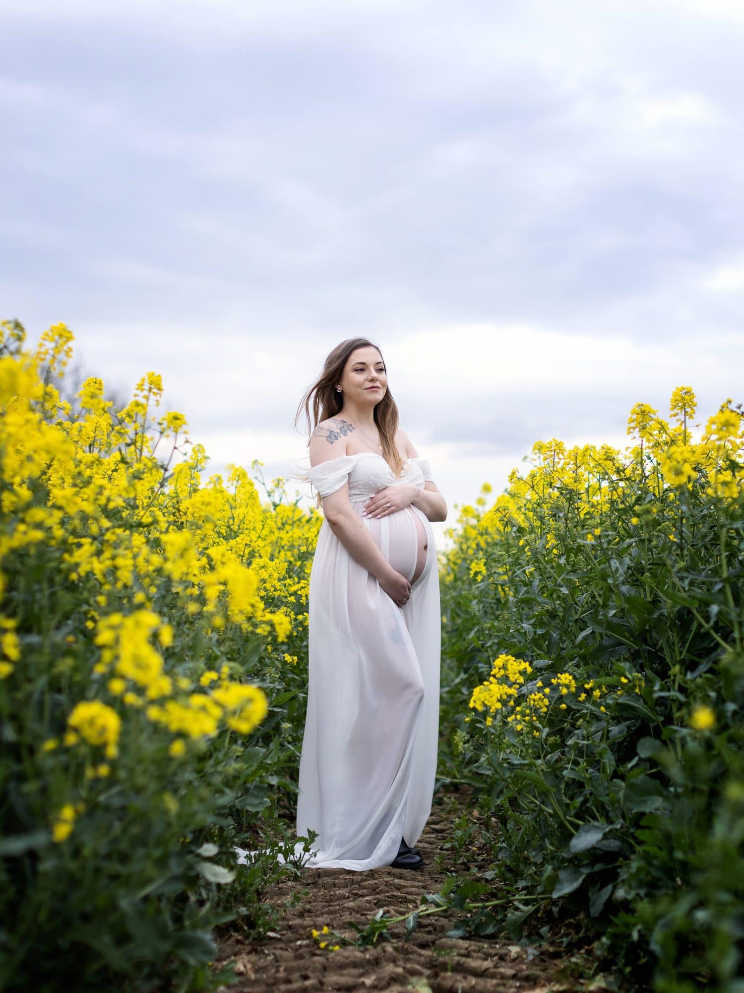 Pregnant lady in white dress poses for Maternity Portrait on Suffolk farm