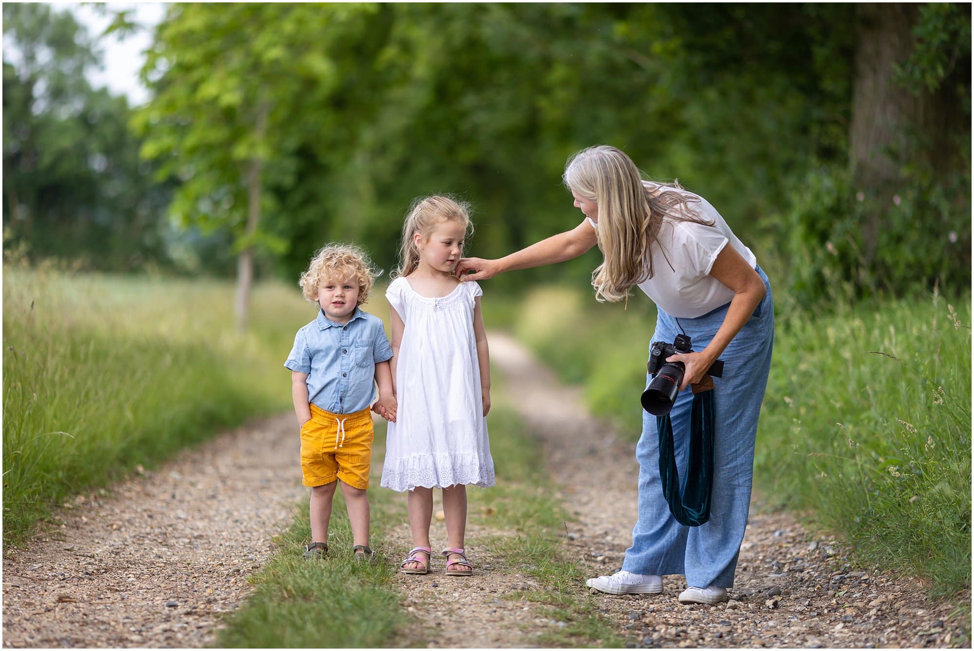 Behind the scenes photo of Alison McKenny photographing a family shoot on a country lane
