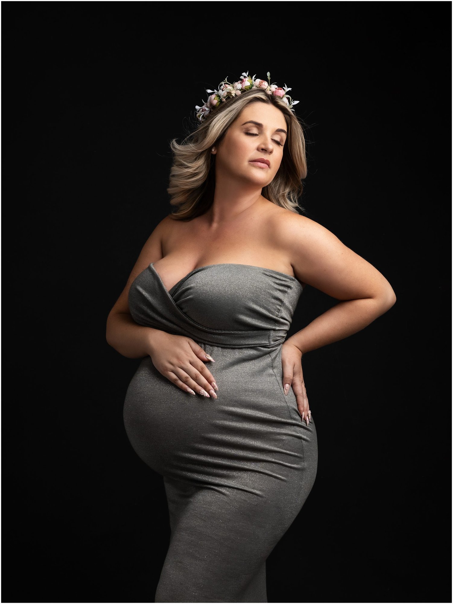 Pregnant lady in silver dress and crown poses during maternity photoshoot with Suffolk Photographer Alison McKenny