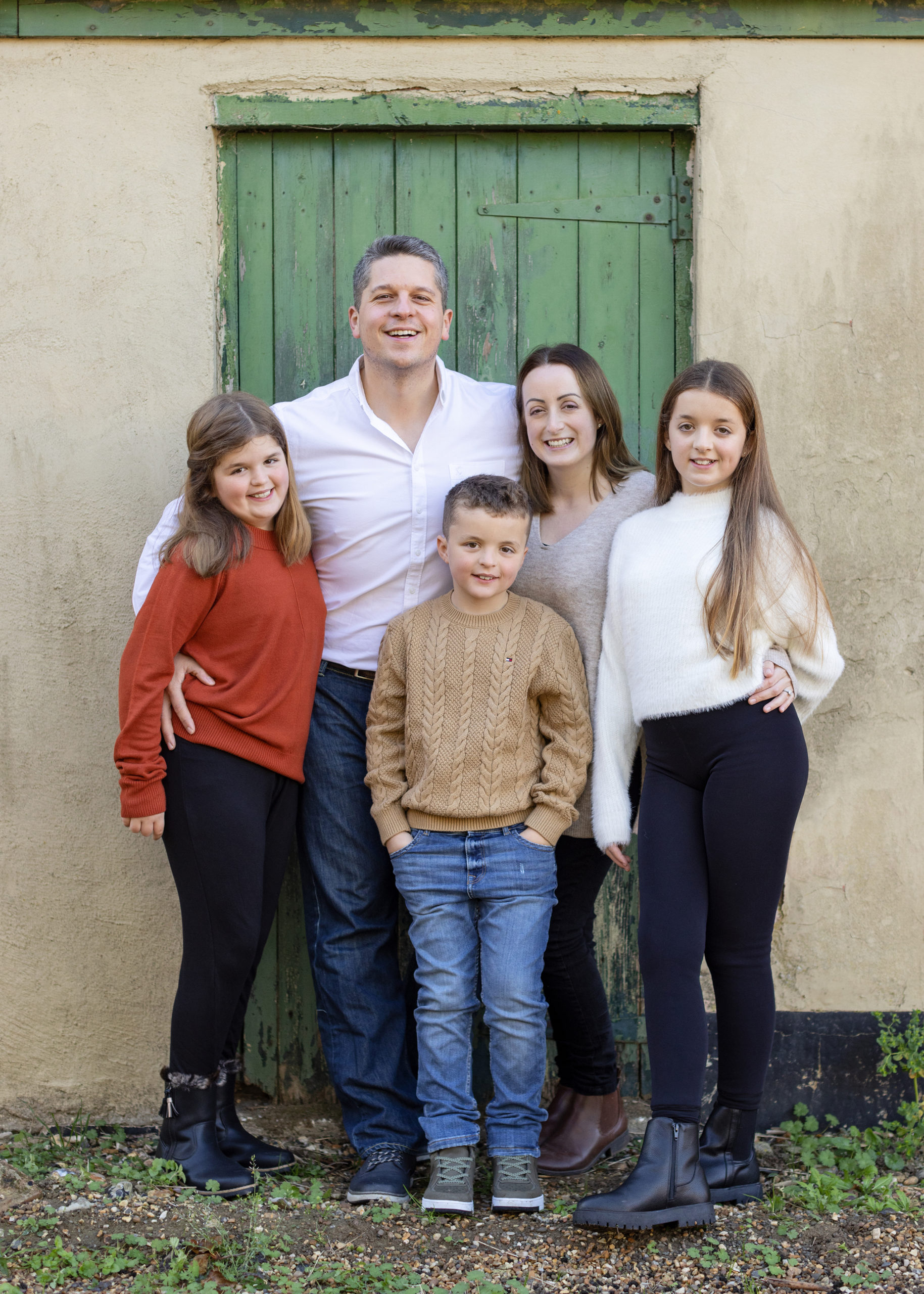 Family of 5 pose for a photo during family photoshoot on suffolk farm