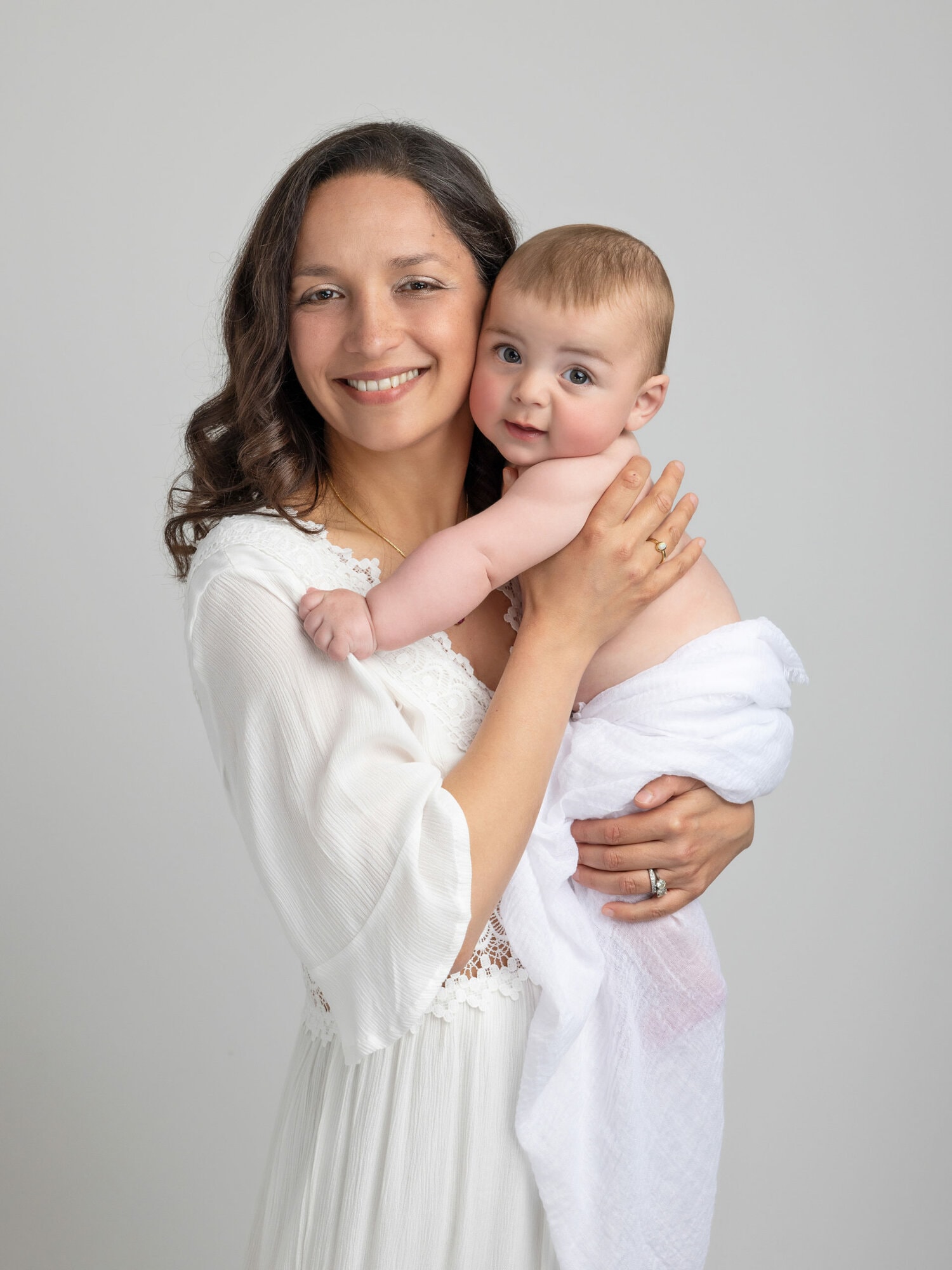 Baby Boy in his Mothers arms, both dressed in white during Baby Photoshoot with Alison McKenny