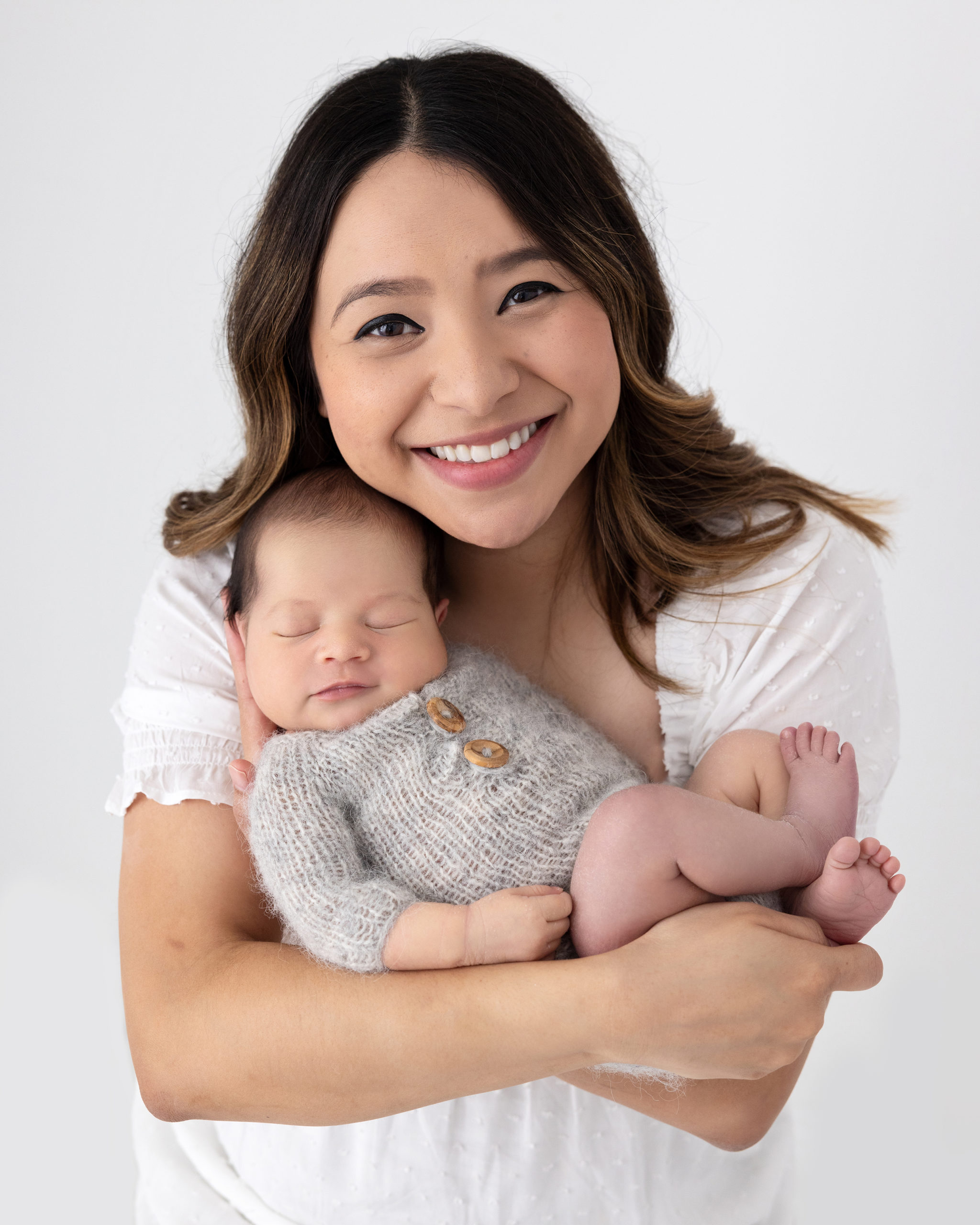 Mother holds her newborn baby during Photoshoot in Suffolk studio