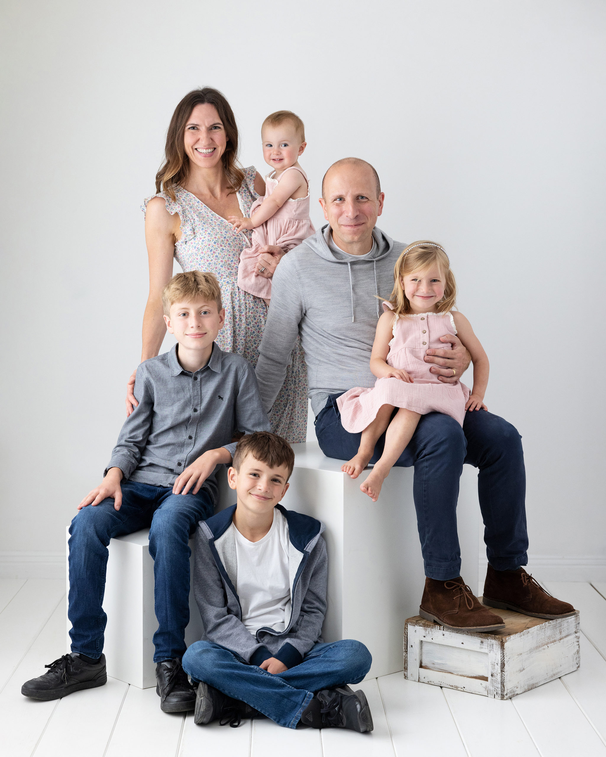 Family of 6 pose for Family Portrait on White background in Suffolk studio