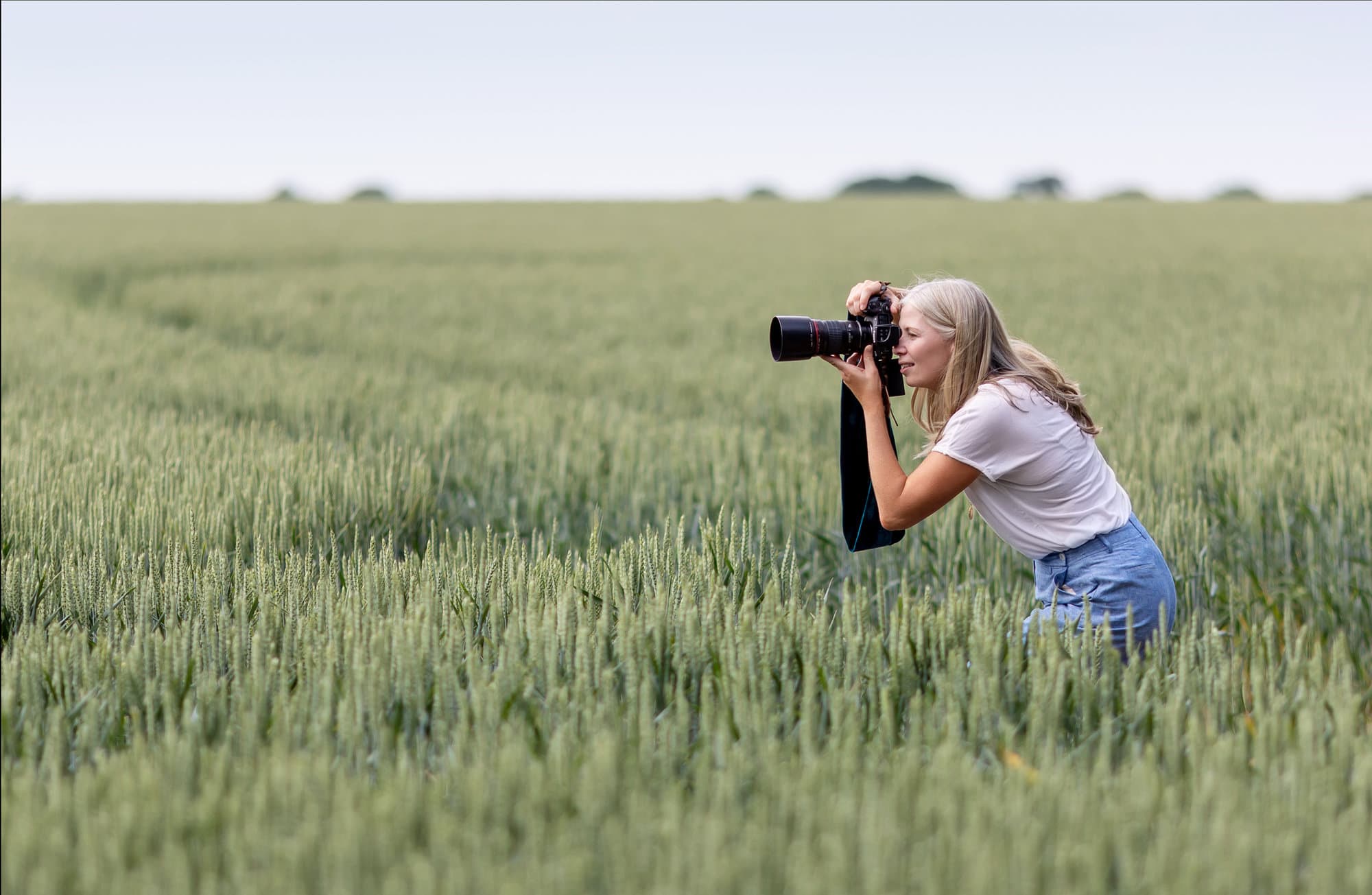 Suffolk Portrait Photographer Alison McKenny takes a photo of a model in a wheat field during a photoshoot
