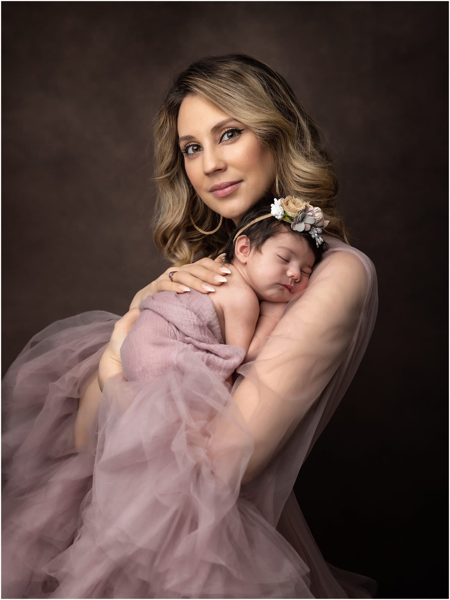 Beautiful Mother holds her Newborn Baby girl while wearing a pink tulle dress during a Newborn Photoshoot with Suffolk Photographer Alison McKenny