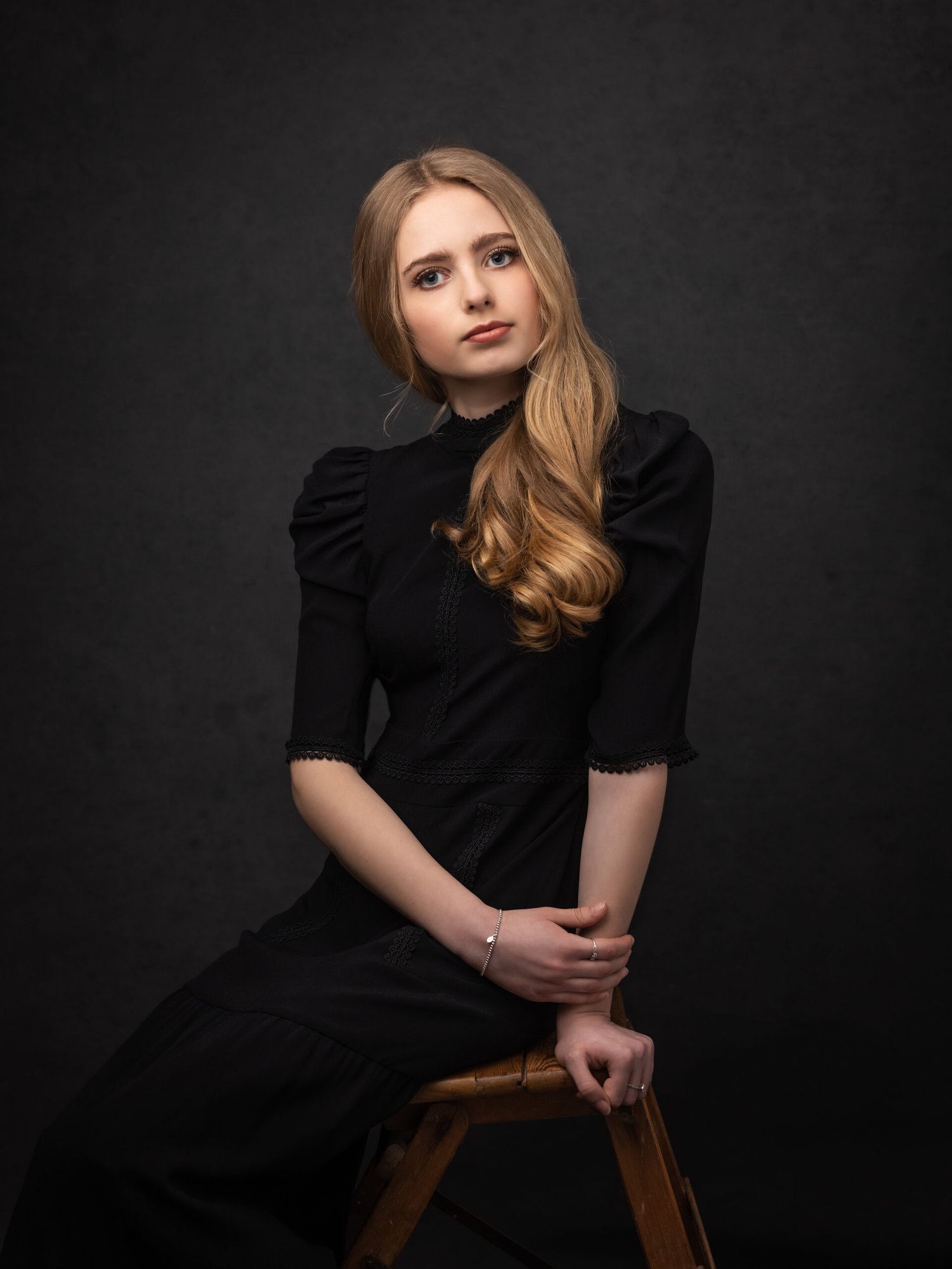 Teenage Girl in a black vintage dress poses for a Fine Art Portrait at Suffolk Photography Studio