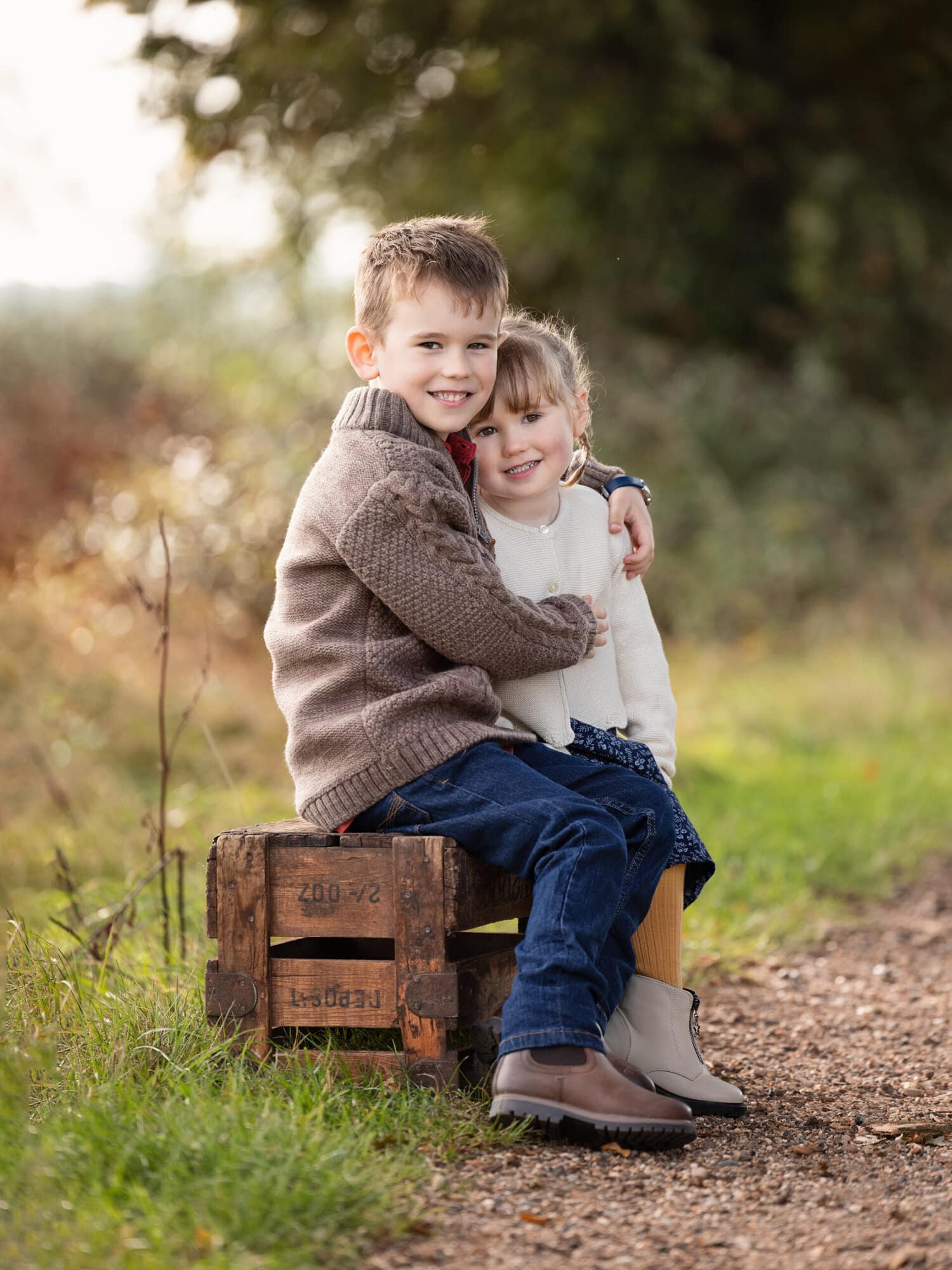 Brother and Sister hug and smile during an Autumn Mini Shoot on Suffolk farm with Alison McKenny