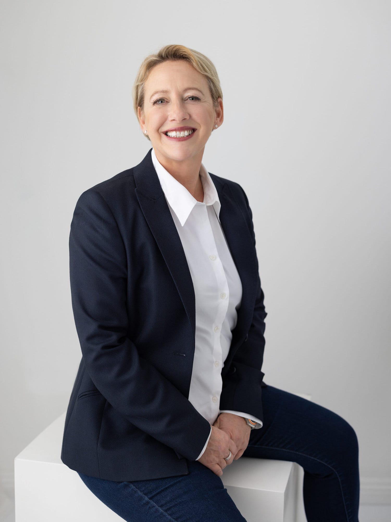 Personal branding portrait of a Nutritionalist and life coach smiling and wearing a navy suit