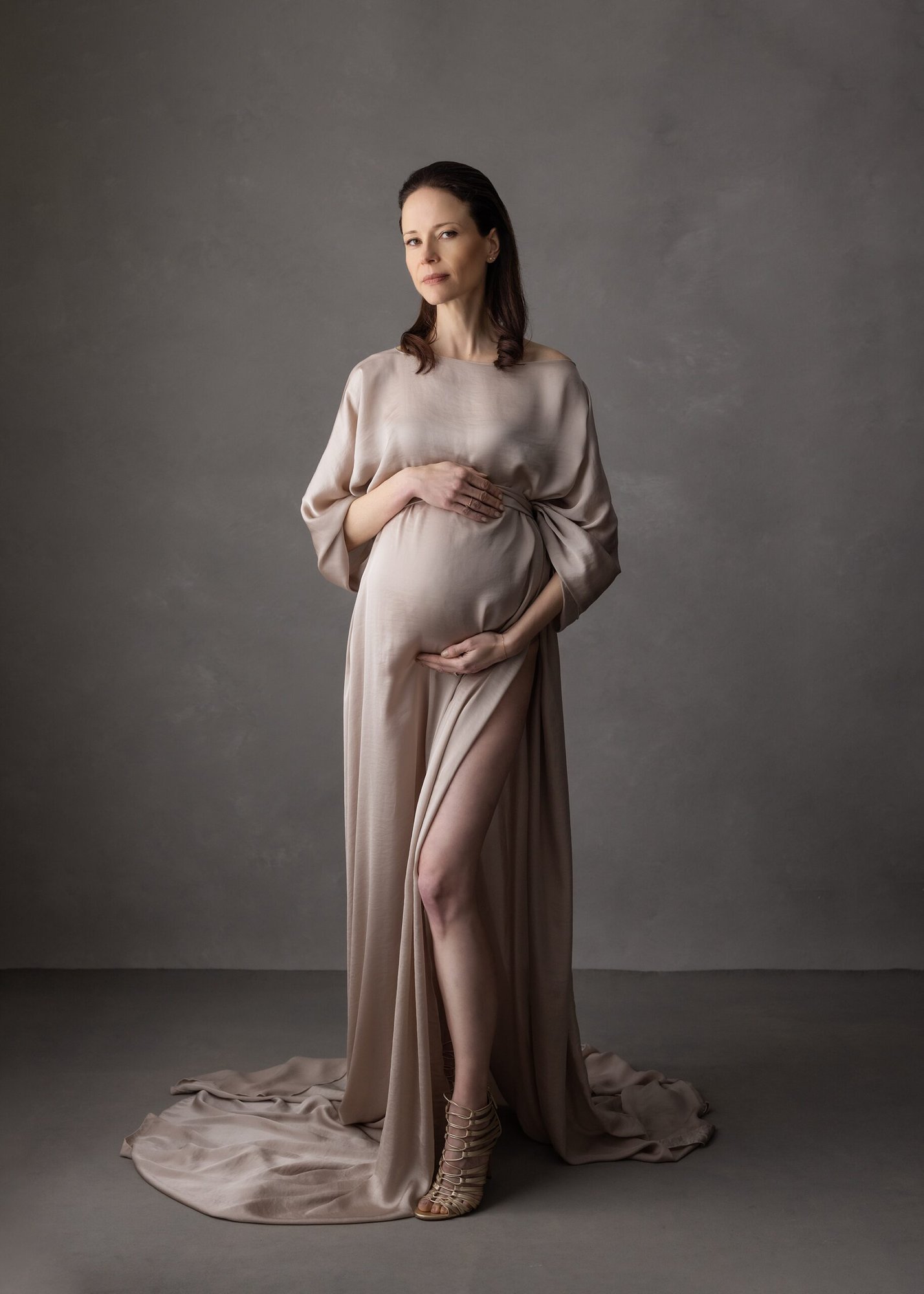 photo of a dark haired pregnant woman wearing a mocha silk dress during Maternity shoot with Alison McKenny Photography